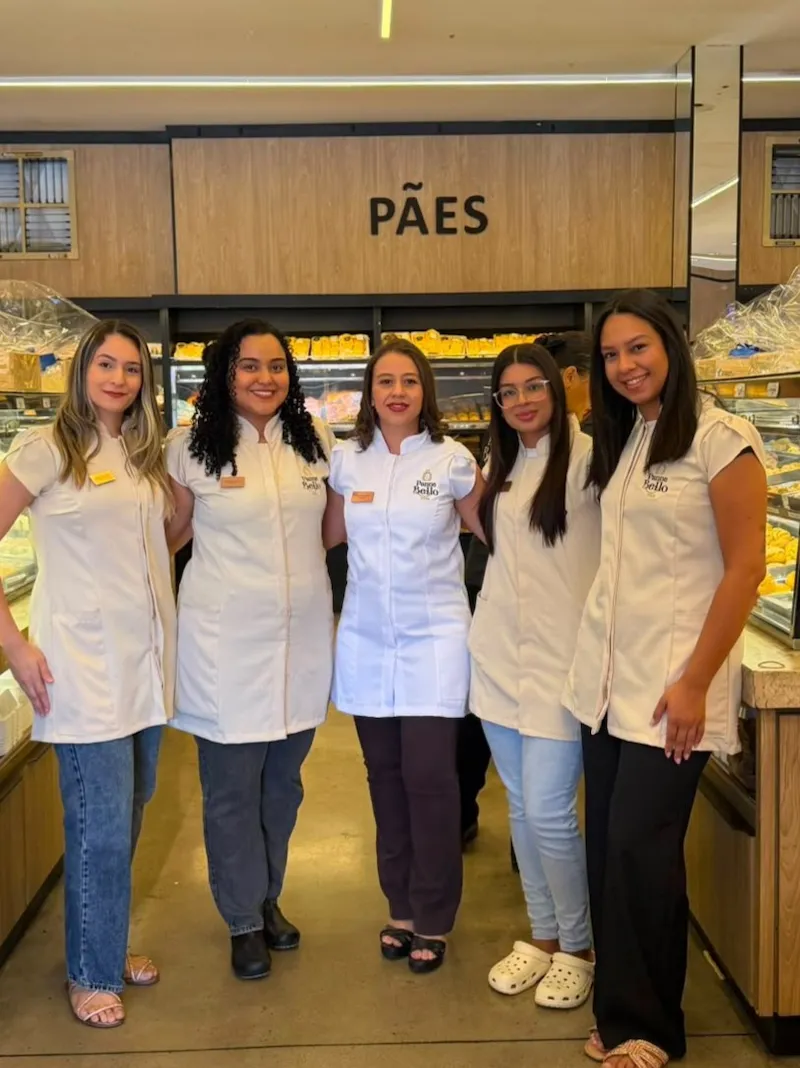 Equipe da Panne Bello reunida em frente ao balcão de pães